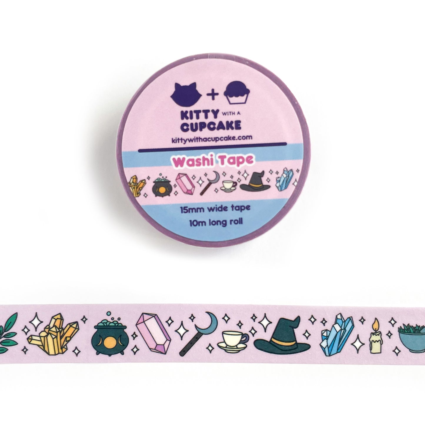 A roll of washi tape with a pink background with a collection of witchy items on it like a crystal cluster, cauldron, sickle, teacup, witch hat, and a candle.